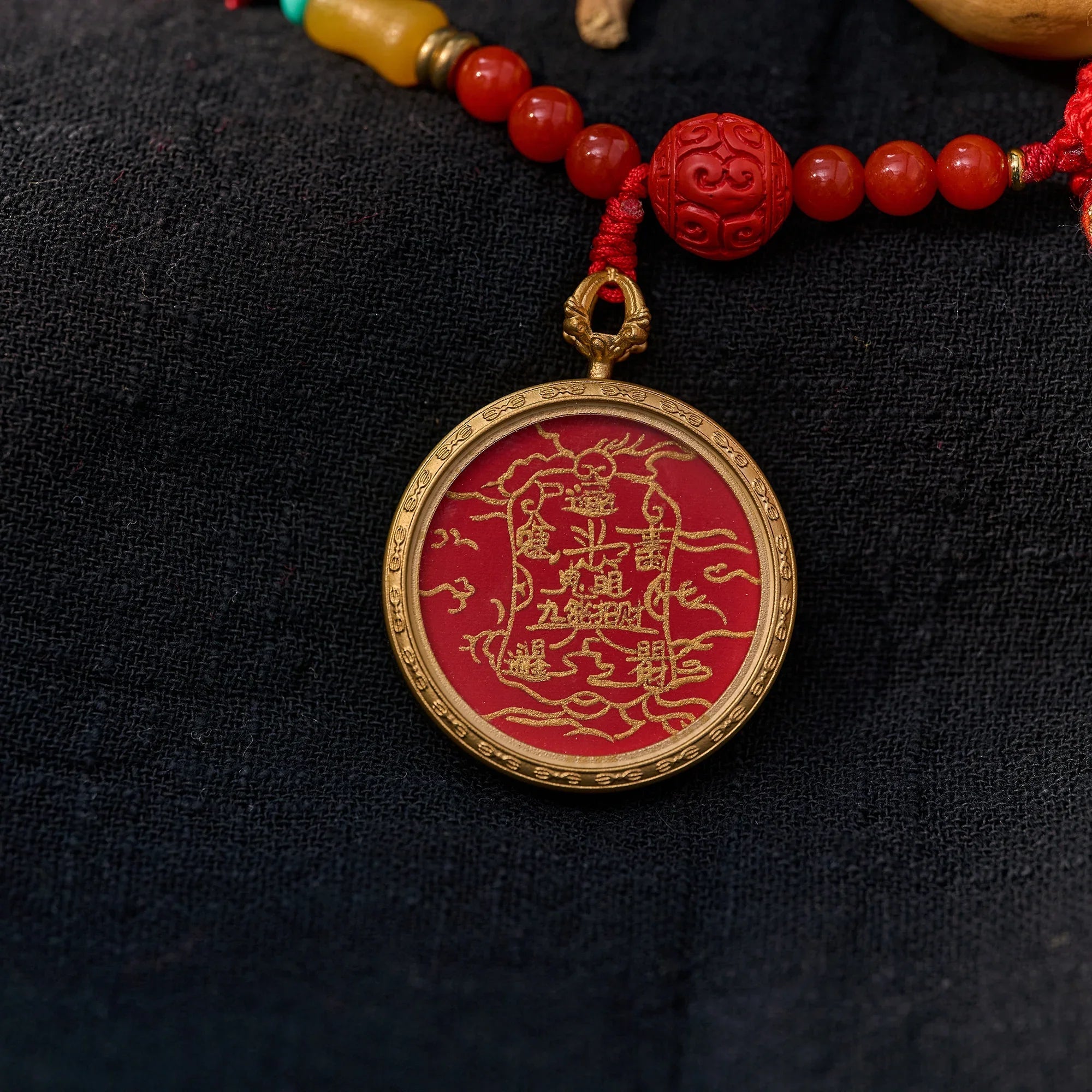Handcrafted Tibetan amulet pendant with gold script on red background, beaded necklace
