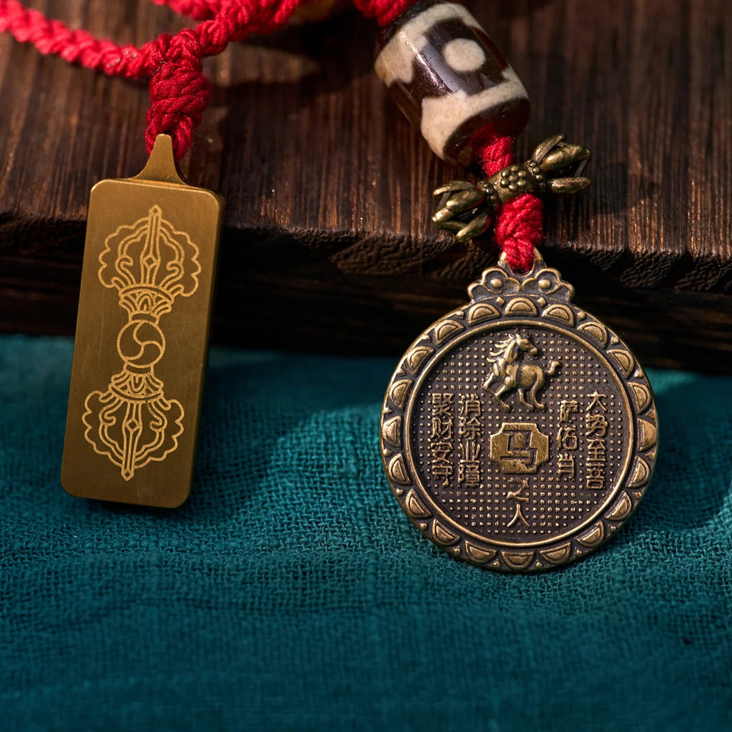 Tibetan style bronze amulet pendants with engraved symbols on red braided cord, spiritual jewelry