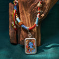 Handcrafted Himalayan necklace with colorful woven cord and painted deity pendant