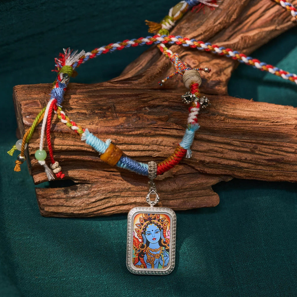 Colorful Tibetan braided necklace with deity pendant on wood, spiritual jewelry