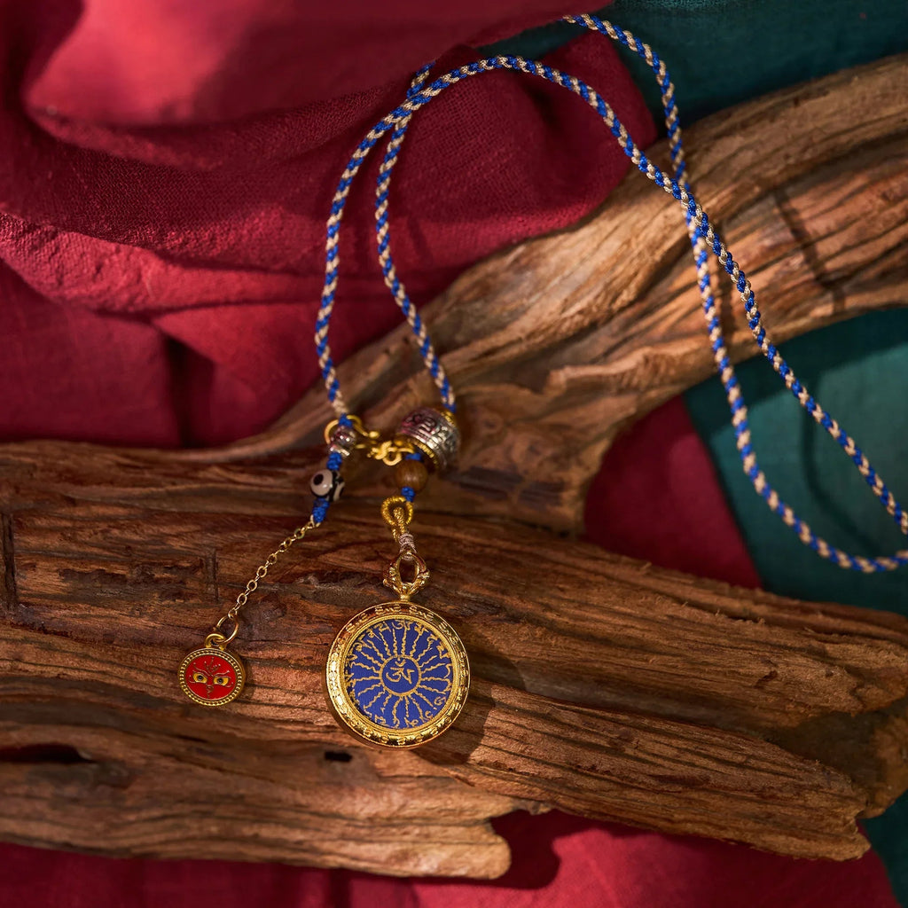 Handcrafted blue and gold Tibetan pendant necklace with intricate patterns on natural wood