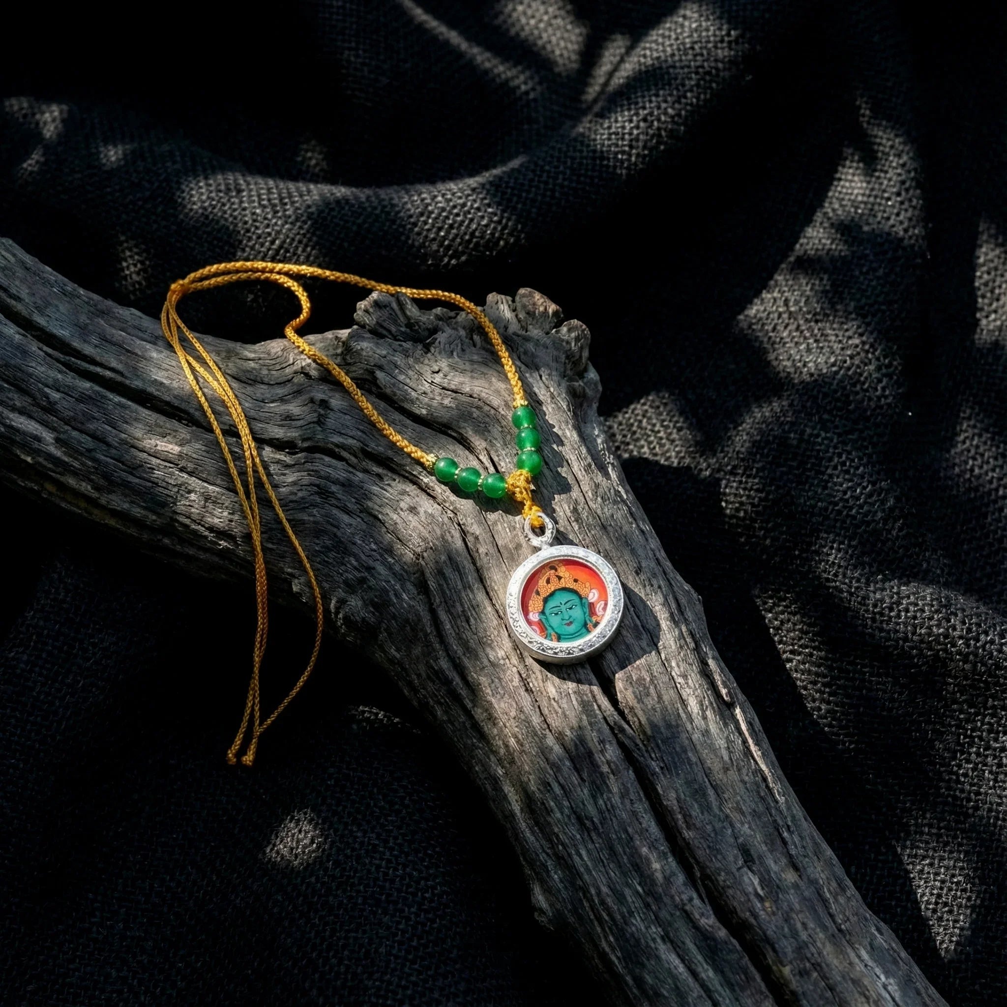 Handcrafted Buddha pendant necklace with green beads on yellow cord, spiritual jewelry on wood