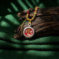 Handcrafted Tibetan amulet necklace with intricate red and gold pendant on rustic wood