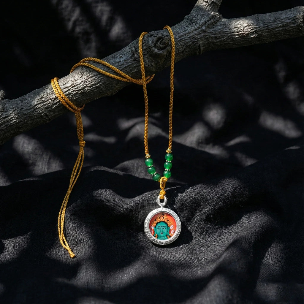 Handcrafted Buddhist pendant necklace with painted deity and green beads on yellow cord