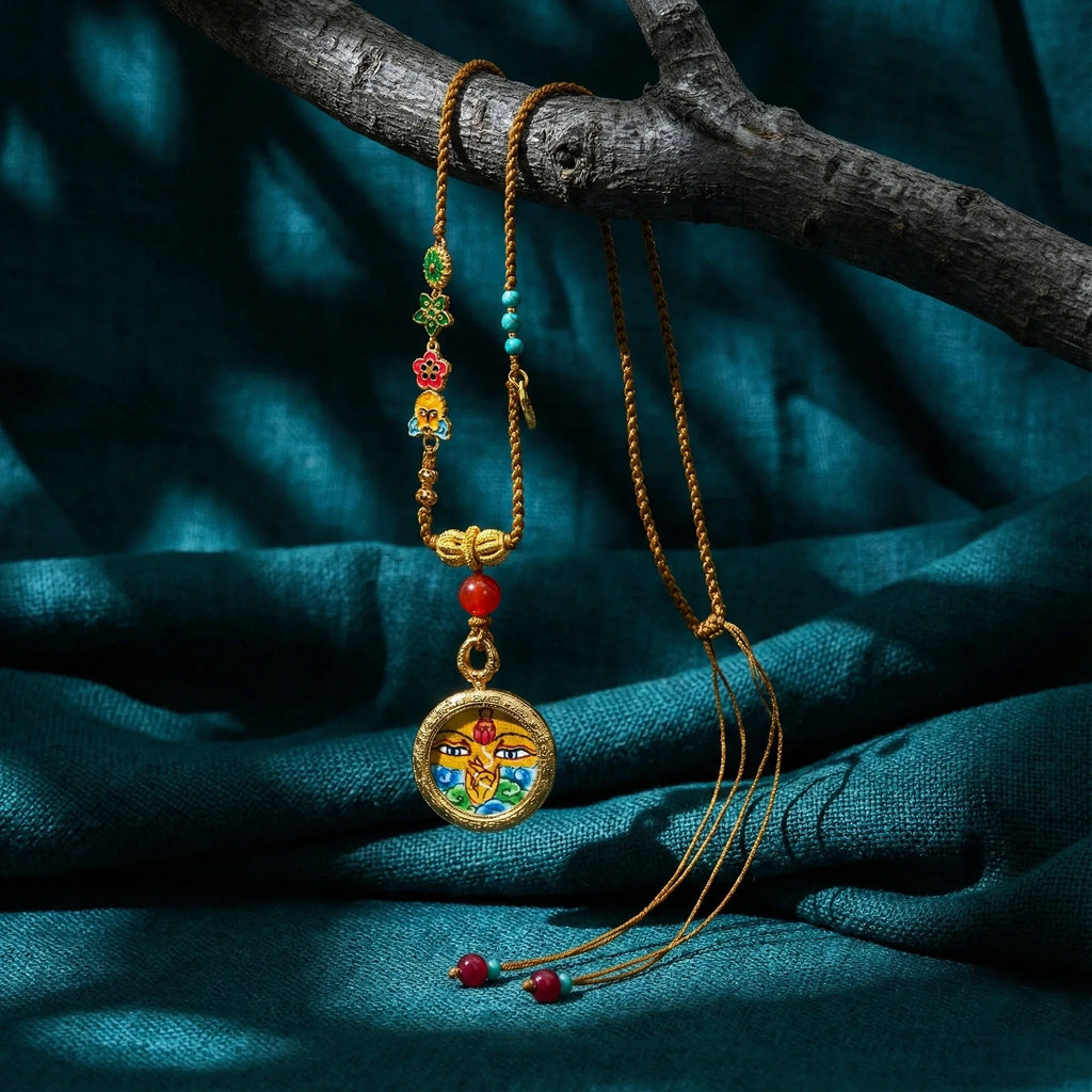Tibetan-style woven necklace with vibrant beads and a gold Buddha-face pendant on teal fabric