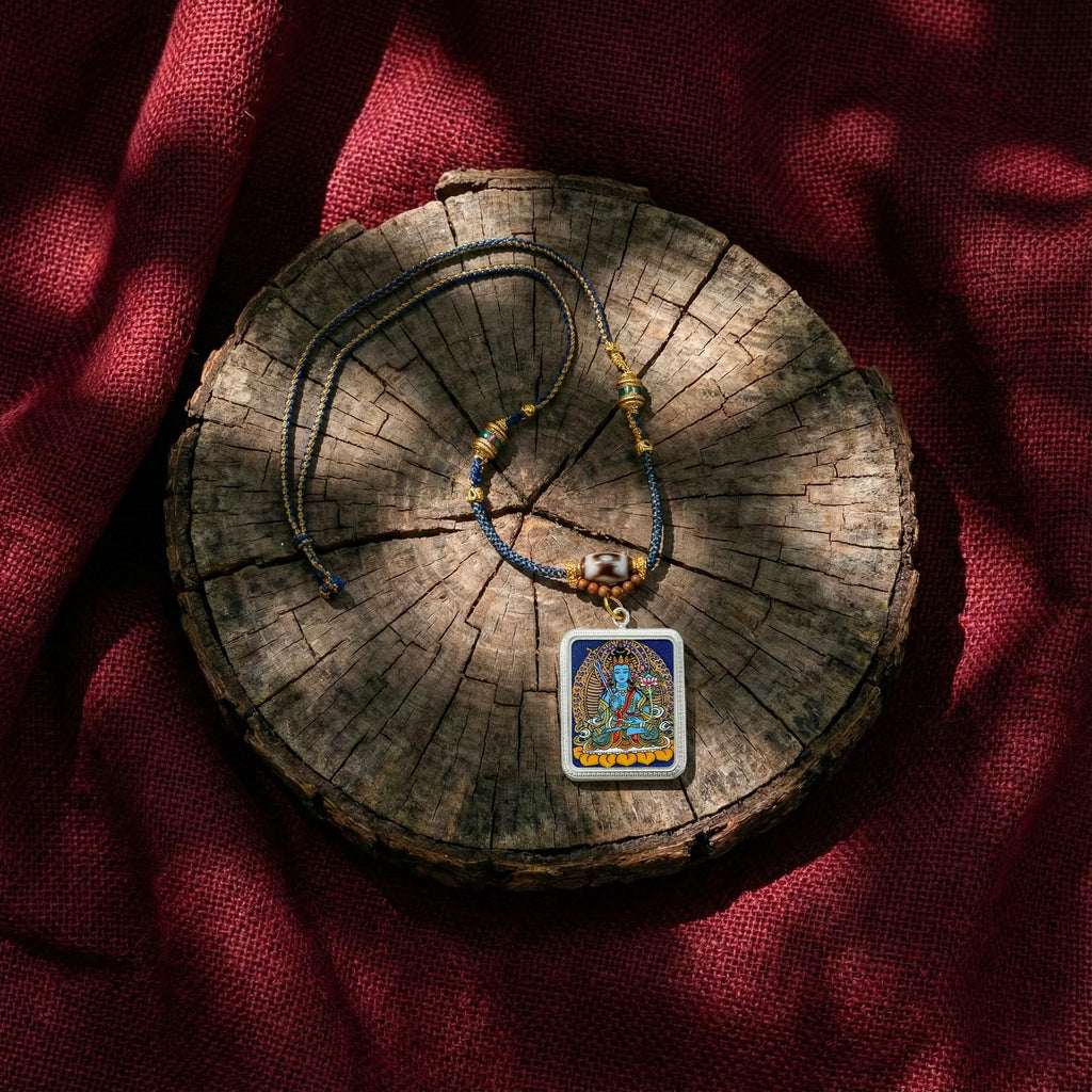 Tibetan Buddhist pendant necklace with colorful deity artwork on braided cord, placed on rustic wood