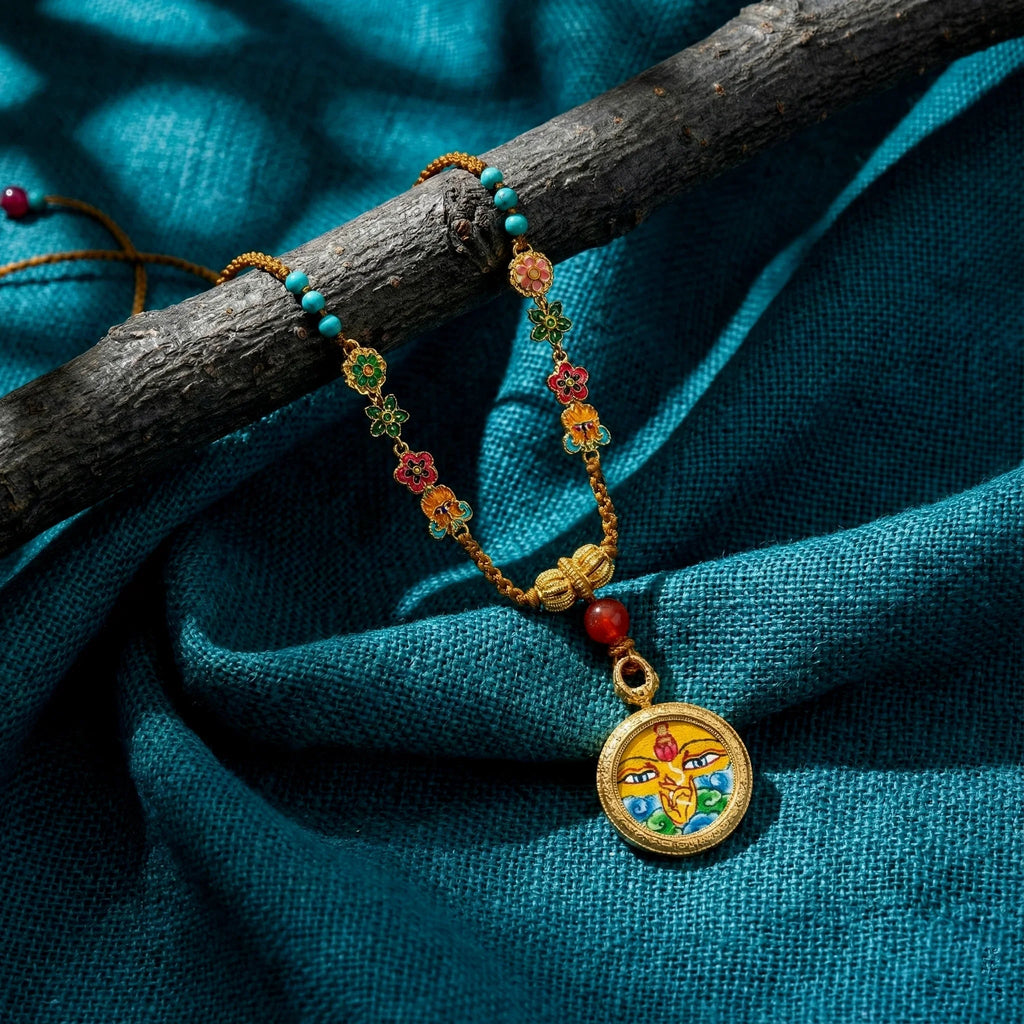 Handcrafted Himalayan pendant necklace with colorful beads and Buddhist symbol on blue fabric