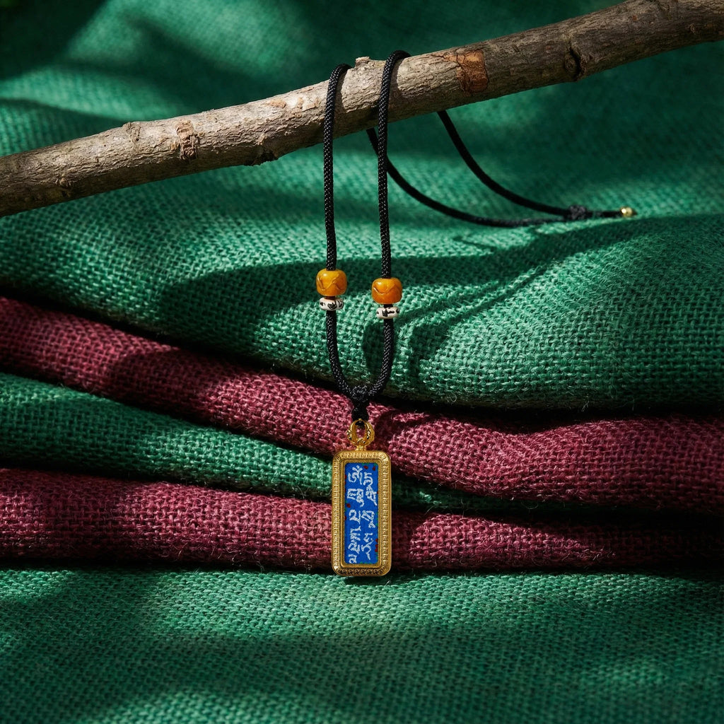 Tibetan mantra pendant necklace with black cord and amber beads on colorful woven fabric
