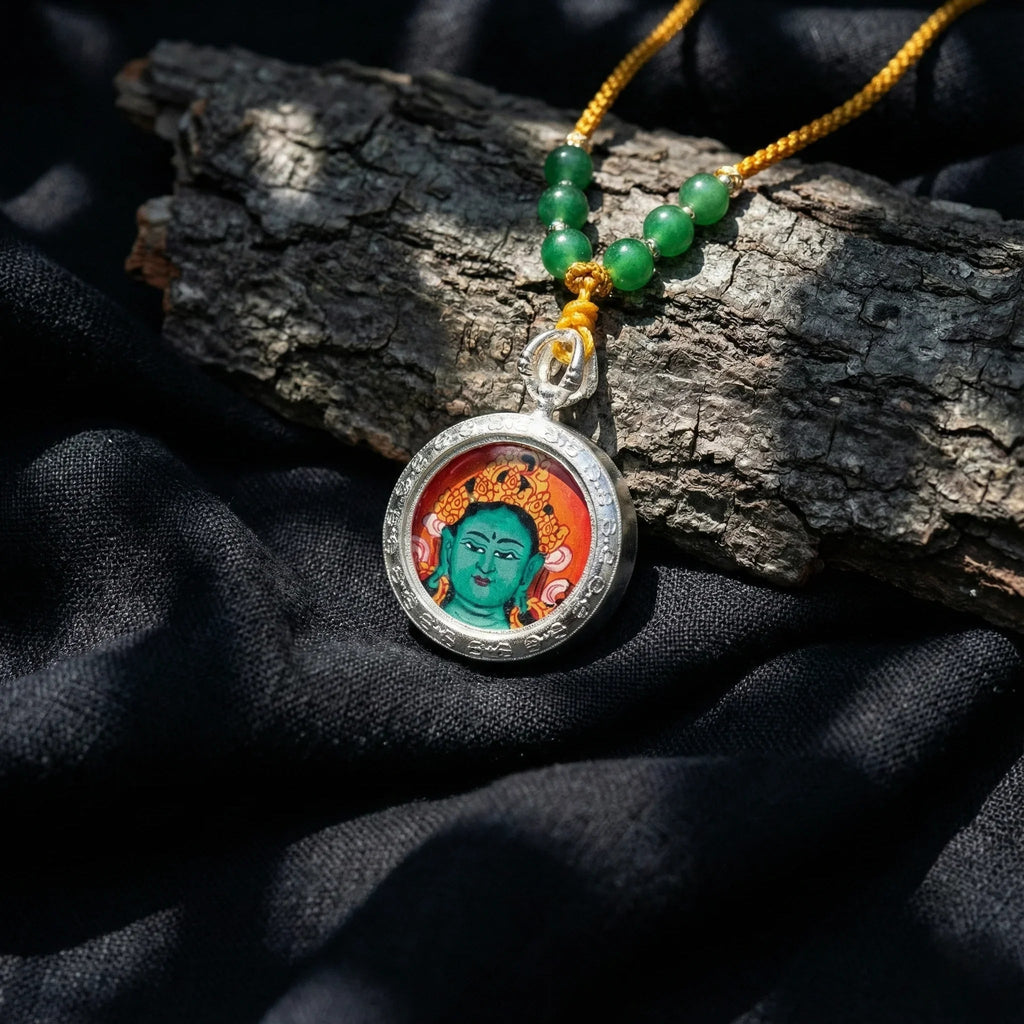 Buddhist amulet necklace with Green Tara pendant and green beads on black fabric